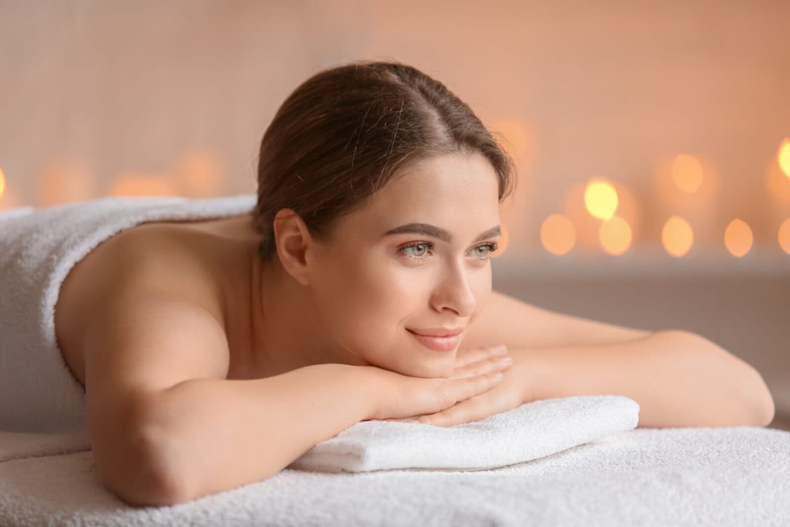 A woman resting calmly in soft, warm candlelight